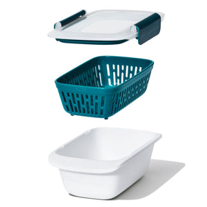 A white rectangular container with snap lock lid and interior colander in blue