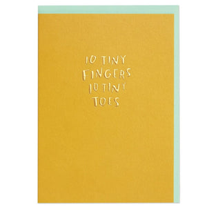 a gold card that reads "10 tiny fingers 10 tiny toes" with a pale blue envelope