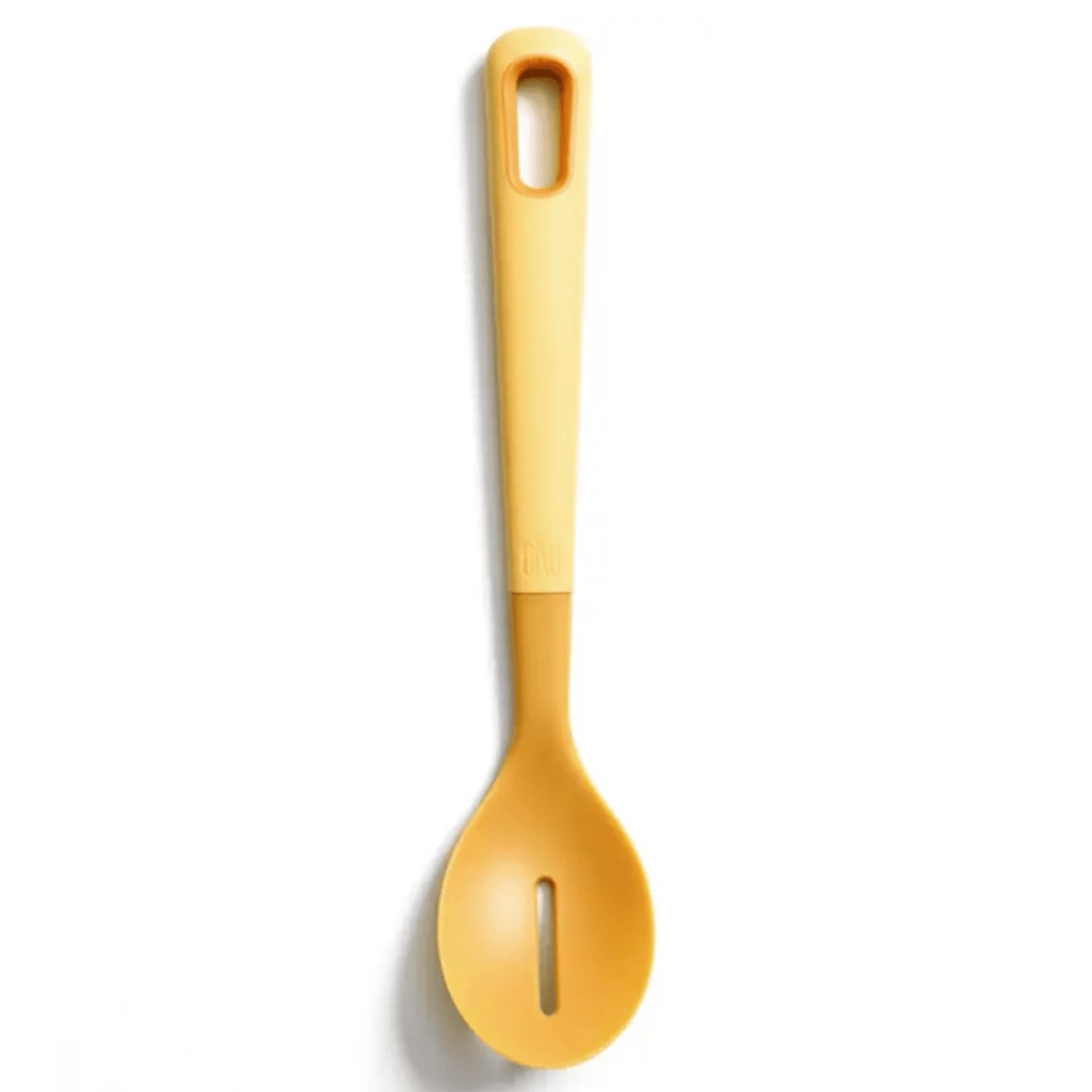 A mustard yellow nylon slotted cooking spoon on a white background, featuring a soft-touch, thick handle for a comfortable grip. Perfect for chefs and home cooks, this ergonomic kitchen utensil is ideal for stirring, mixing, and serving.