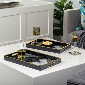 two rectangular art deco style trays in black with gold trim and a gold, black, and cream tile pattern