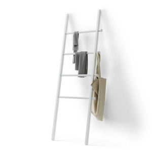 White ladder holding bag and clothes on white backdrop