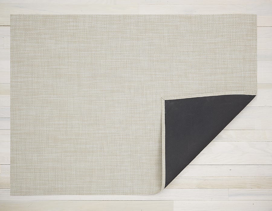 a rectangular woven floor mat made of eco friendly vinyl yarn in a pale khaki colour