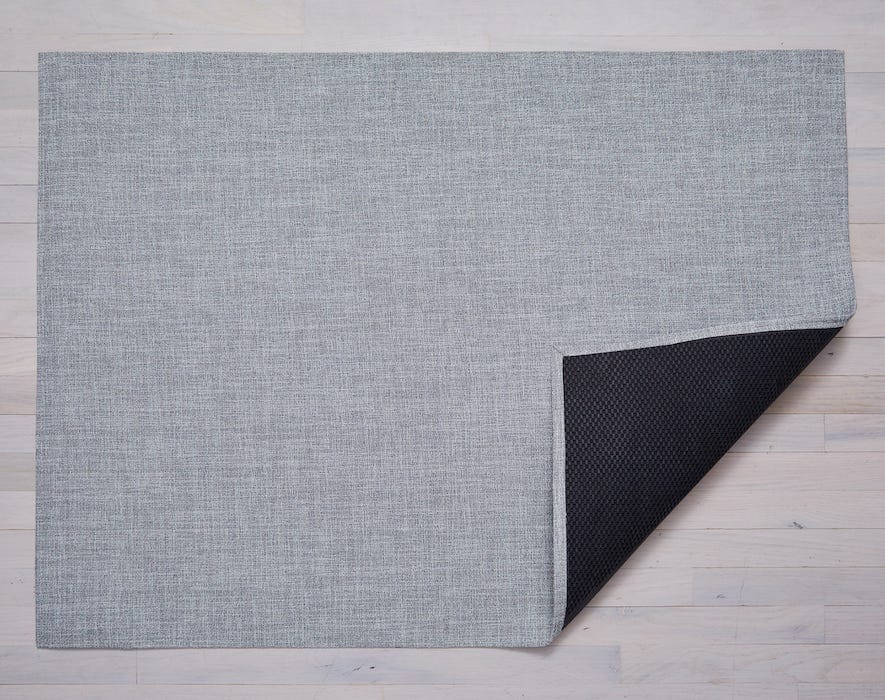a rectangular woven floor mat made of eco friendly vinyl yarn in a soft greyish white