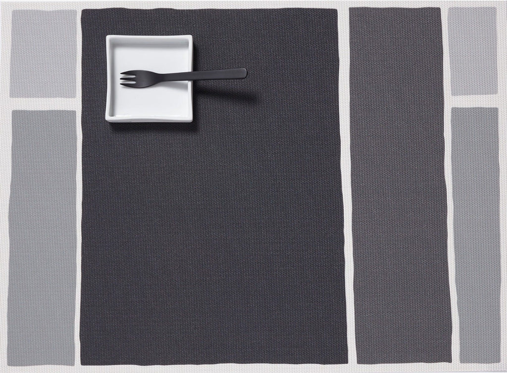 a rectangular placemat made of eco friendly vinyl yarn printed with light to dark gray rectangles in an abstract print