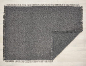 an unbacked, rectangular, woven, floor mat in medium grey with fringes along each edge made of eco friendly vinyl yarn