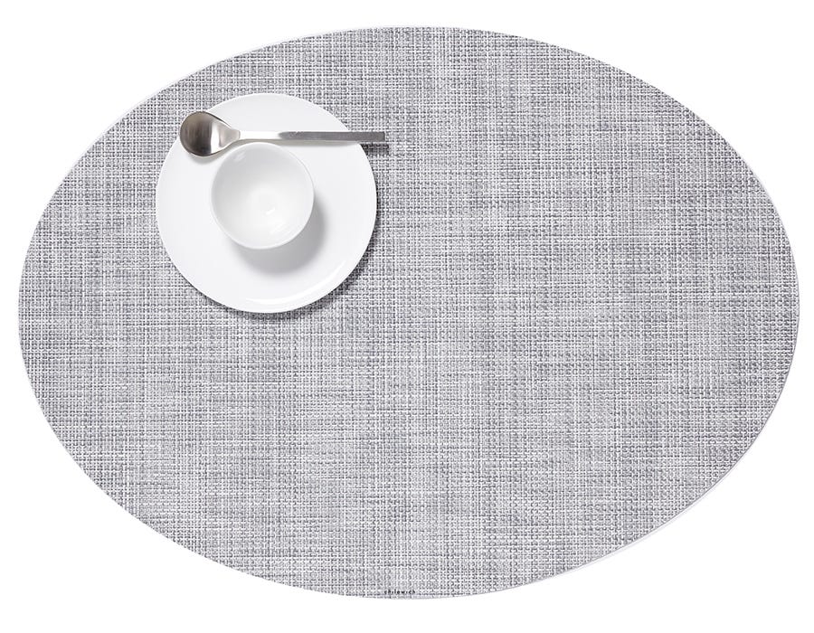 an oval, basket weave style, woven placemat in a soft mist grey
