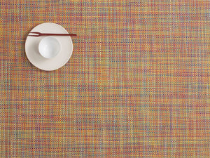 a rectangular basket weave style woven placemat with multi colours made of eco friendly vinyl