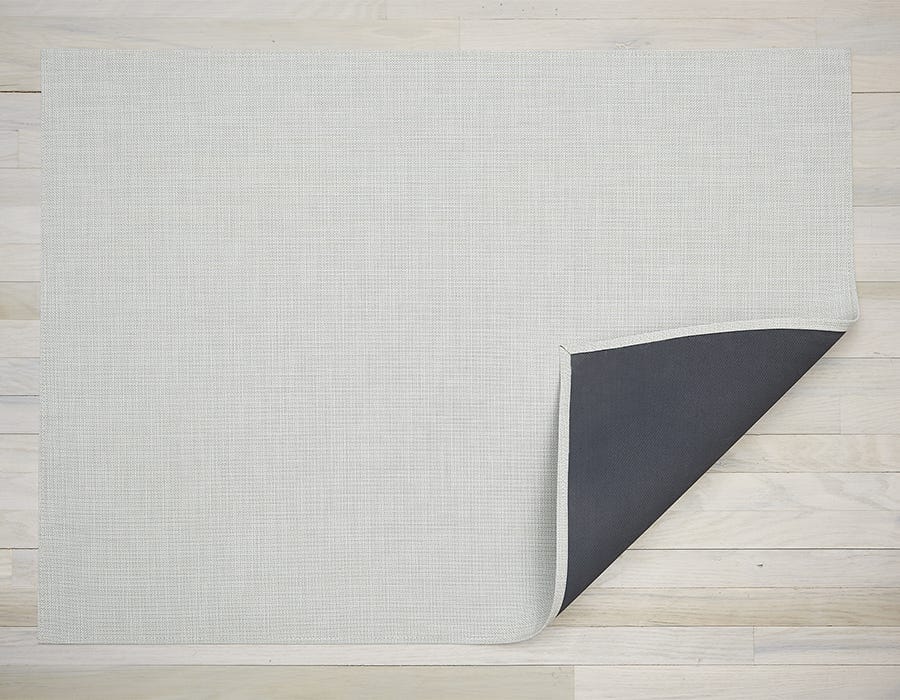 a rectangular woven floor mat made of eco friendly vinyl in cool off white