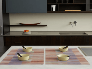 Modern kitchen island displaying a placesetting of four colourful striped placemats