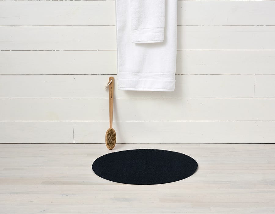 a circular black dot shag mat made of eco friendly looped vinyl yarn
