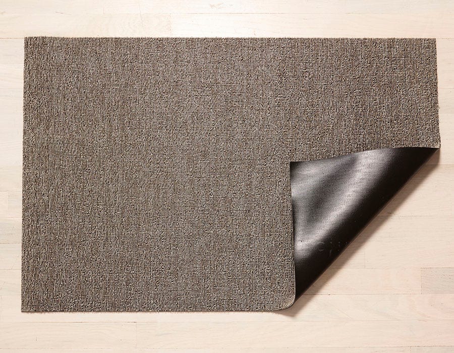 a soft taupe heathered rectangular floor mat made of eco friendly looped vinyl yarn, backed with black commercial rubber