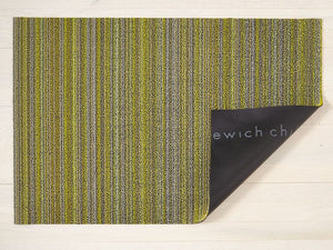 a rectangular floor mat in a skinny stripe design in shades of grey and lime green, made of eco friendly looped vinyl yarn, backed with black commercial rubber