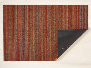 a skinny striped design rectangular floor mat in shades of orange, made of eco friendly looped vinyl yarn, backed with black commercial rubber
