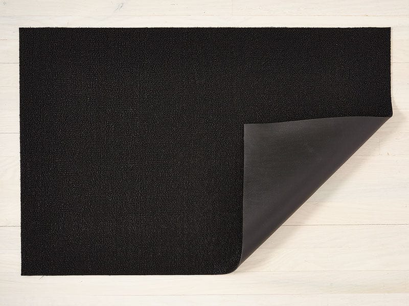 a solid black rectangular floor mat made of eco friendly vinyl shag, backed with black commercial rubber