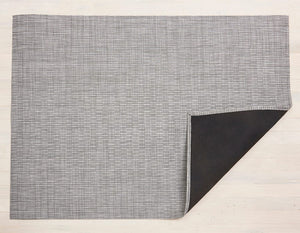 a rectangular woven floor back in shades of medium to light gray backed with non slip material