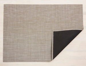 An off white/taupe rectangular woven vinyl floor mat with black non slip backing