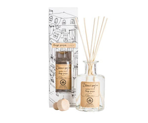 A clear, glass bottle of Linen scented diffuser, with 7 bamboo reeds in the neck of the bottle and a lable printed with " Batons a parfum, fragrance diffuser, linge propre, linen" and the Lothantique logo. Shown with a second bottle in white packaging with black line drawings of French houses.