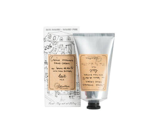 Milk scented shea butter hand cream in a silver tube with a striped beige label printed with "creme mains, hand cream, beurre du karite, shea butter, lait, milk" and the Lothantique logo, to the left is a white box, with the same label and line drawings of French houses.