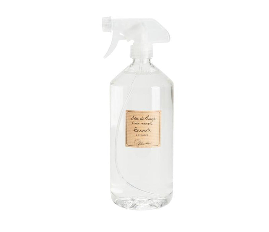 Lavender linen water in a clear, plastic bottle with a spray nozzle. A striped, beige label is printed with "eau de linge, linen water, lavande, lavender" and the Lothantique logo.
