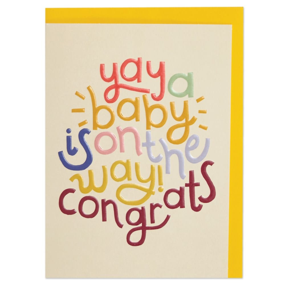 white greeting card with yellow envelope, colourful front text readys "yay a baby is on the way! congrats"